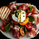 Heirloom Tomato, Prosciutto & Burrata with Garlic-Basil Oil First Image